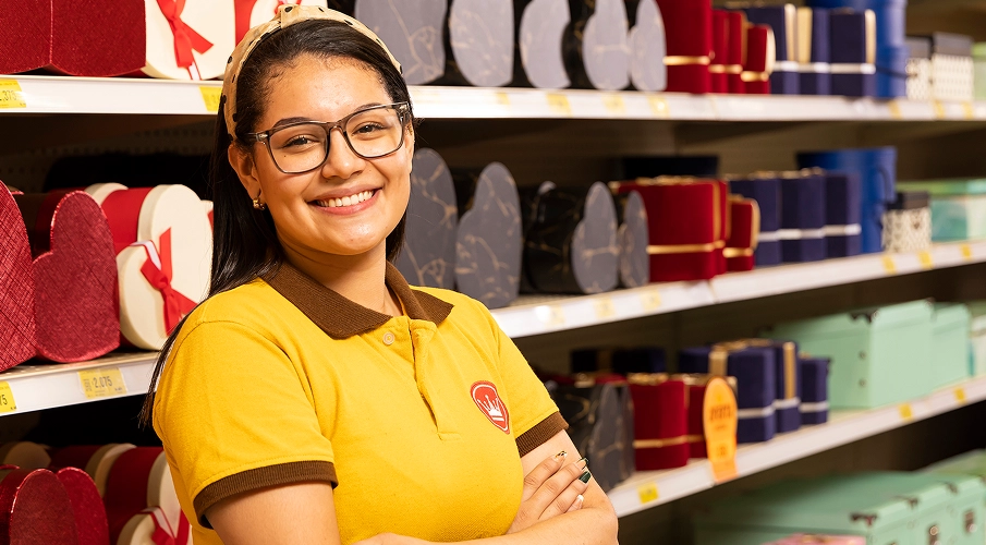 Colaborador sonriendo en el pasillo de la tienda